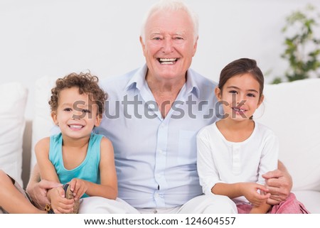 Grandfather and children sitting on the sofa in the living room