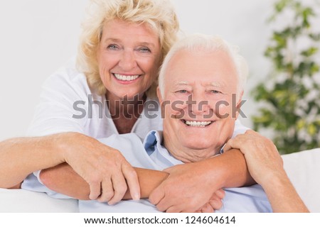 Happy old couple portrait hugging on the sofa