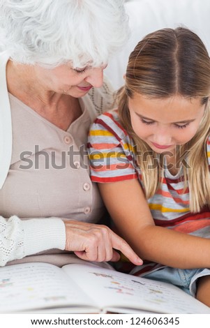 Girl reading book with granny on the couch