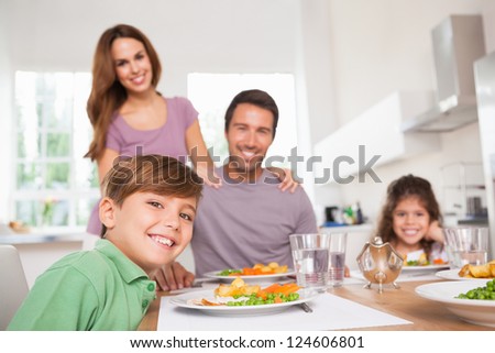 Family looking at the camera at dinner time in kitchen
