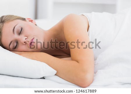 Serene woman sleeping in white bedroom at day
