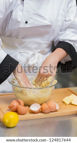 Pastry chef mixing dough with hands