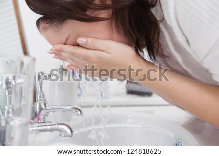 Close-up side view of woman washing face