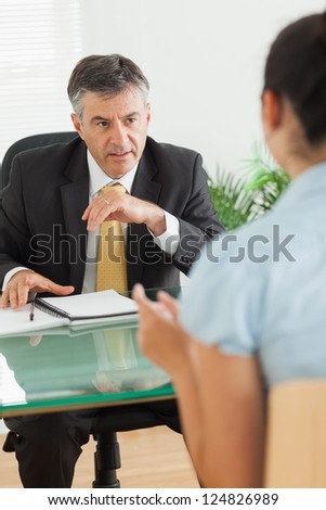 Well-dressed businessman speaking with a woman in his office