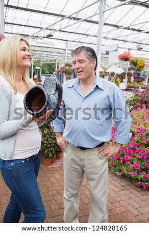 Couple laughing at flower pot shaped like boot in garden center