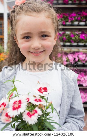 Little child holding a flower in garden center