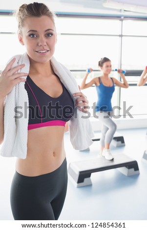 Woman with towel around her neck at aerobics class in gym