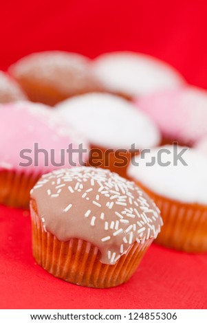 Muffins with icing sugar on a red tablecloth