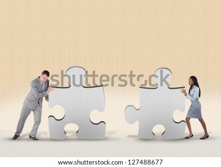 Business people pushing two jigsaw pieces together
