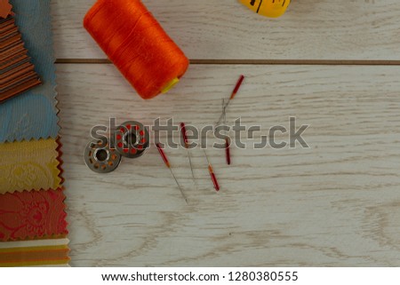 Close-up of textile, thread rolls and various equipments on a table