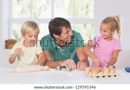 Smiling woman with a rolling pin in hands in kitchen
