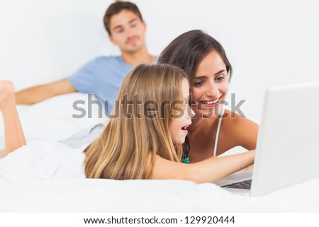 Family sitting with a laptop on the bed in the bedroom