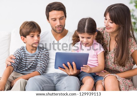 Happy family looking at tablet pc on the couch