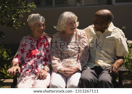 Front view of happy senior friends interacting with each other in garden