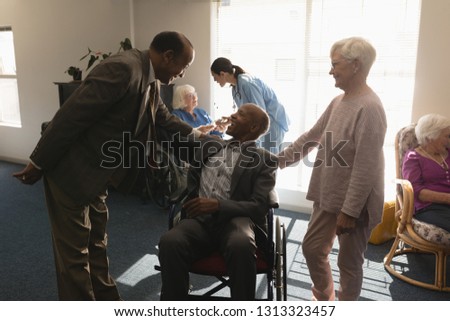Front view of senior friends interacting with each other at nursing home