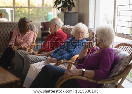 Side view of group of senior friends interacting with each other at nursing home
