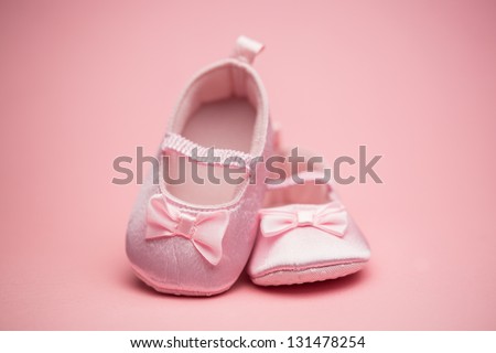 Pink baby booties on pink background