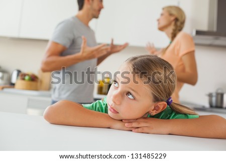 Angry parents arguing behind a sad girl at home