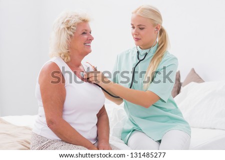 Home nurse examining an aged woman at home