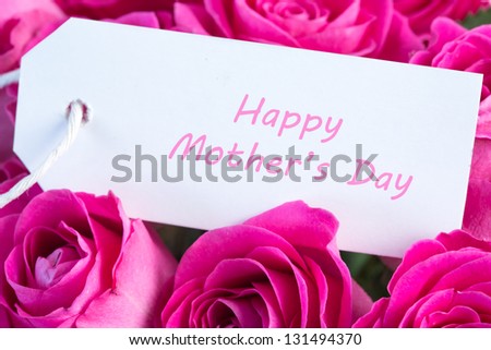 Close-up of a bouquet of pink roses with happy mothers day written in pink on a card