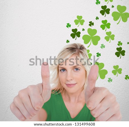 Girl in green t-shirt giving thumbs up with copy space on shamrock background
