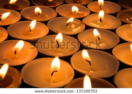 Many tea light candles burning