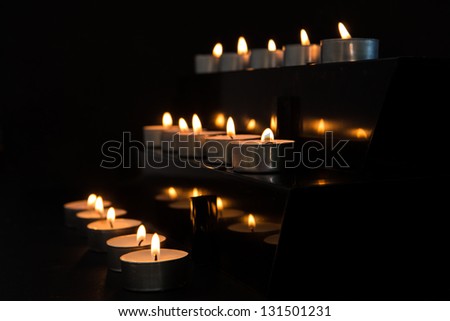 Tea light candles at the alter in the darkness