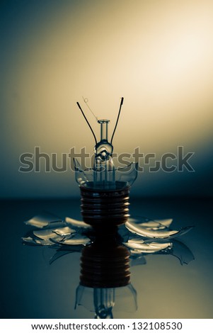 Clear light bulb broken on a reflective surface