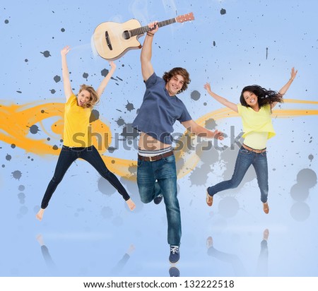 Young man with guitar and two girls jumping for joy with yellow smoke trail and grey paint splatters on blue background