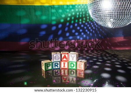 Block spelling gay pride under light of disco ball with rainbow flag