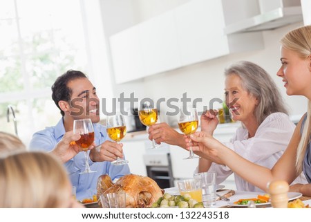 Happy family raising their glasses at thanksgiving dinner
