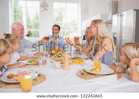 Adults raising their glasses at thanksgiving dinner without children