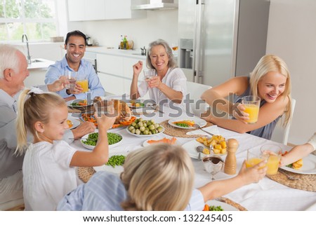 Happy family raising their glasses together in the kitchen