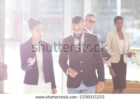 Front view of mixed-race young business people interacting with each others in office lobby