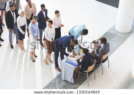 High angle view of diverse business people checking in at conference registration table in  lobby