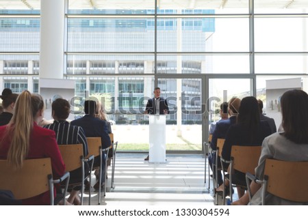 Front view of male mixed race businessman speaks in a business seminar in office building