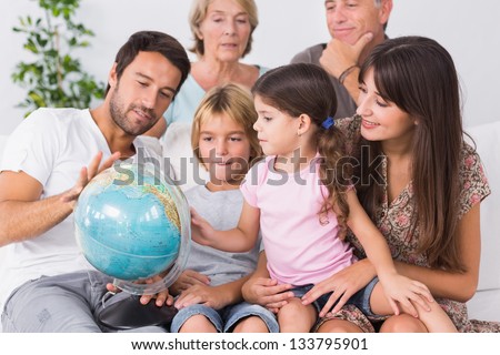 Happy family looking at globe on the couch
