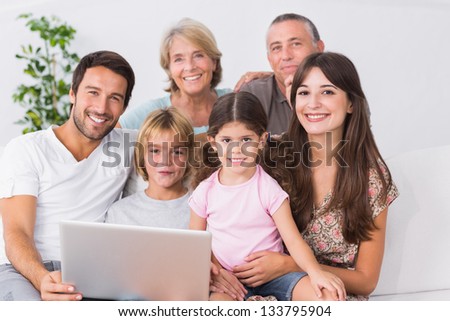 Happy family on couch using laptop in the living room