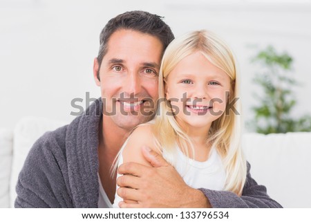 Father hugging his daughter and looking at camera
