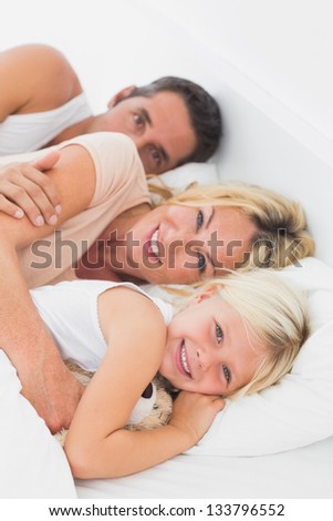 Family embracing together on a bed in the bedroom