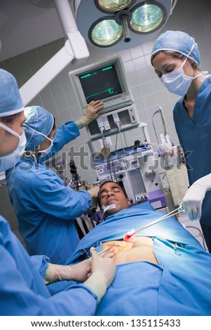 Serious doctors operating a patient in operating theater