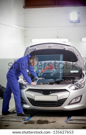 Man repairing car with open hood and small futuristic interface with car diagram