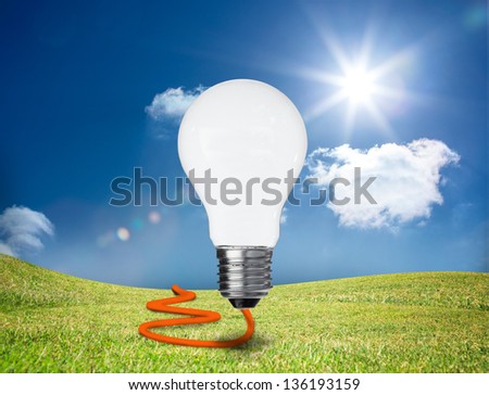 Light bulb with orange cord floating in a green field
