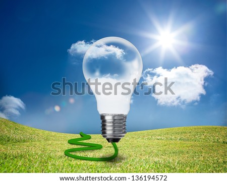 Transparent light bulb floating in a green field with a green cord