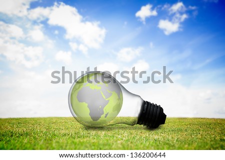 Earth inside light bulb on the grass