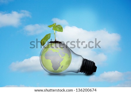 Light bulb with plant and earth against sky background