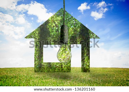 Light bulb made of leaves on blue sky and grass background