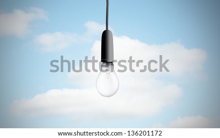 Light bulb hanging on sky background