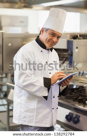 Smiling chef using digital tablet in the kitchen