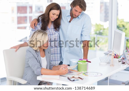 United smiling team of interior designer at desk in bright modern office